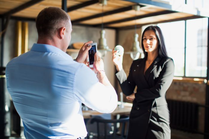 Foto de mulher gravando vídeo sobre produto.